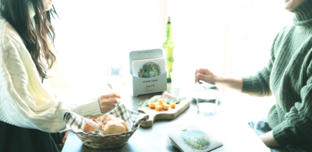 食事をしているテ―ブルにMASK CASE・CASE STAND Aが置かれている